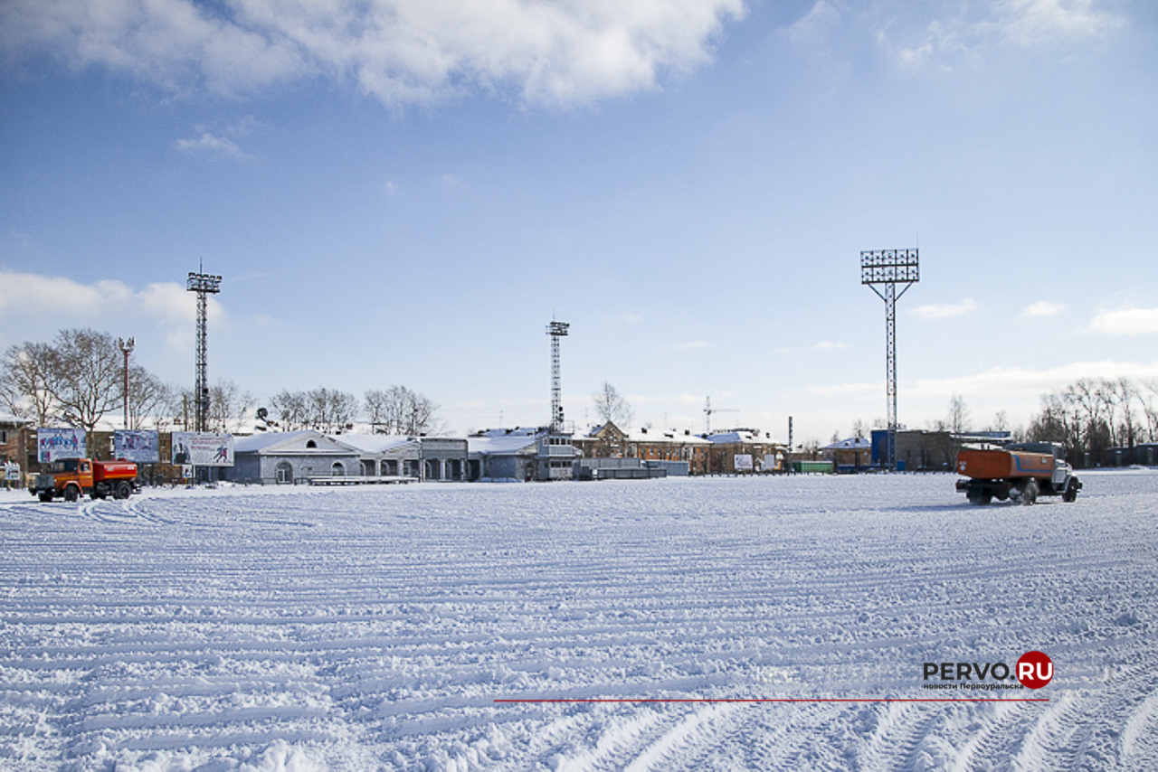 На большом поле городского стадиона начали заливать лёд